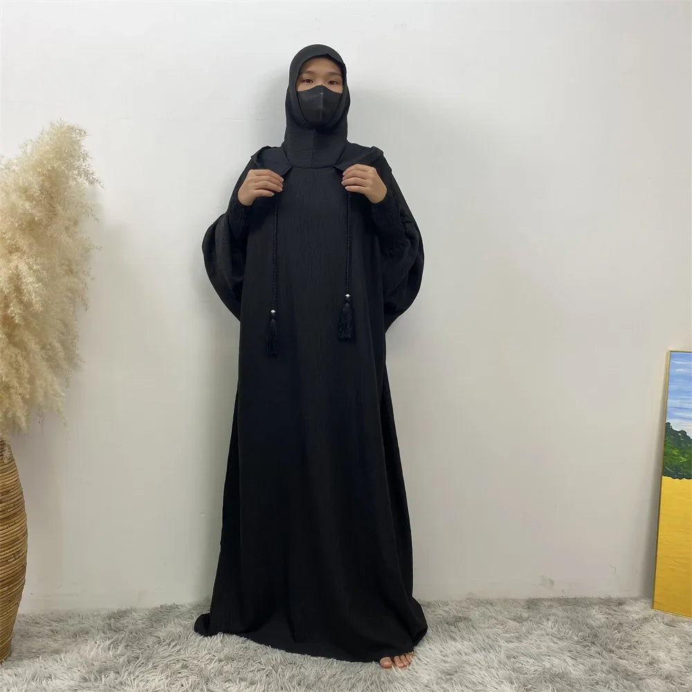 Robe longue à capuche et manches chauve-souris, couleur unie.